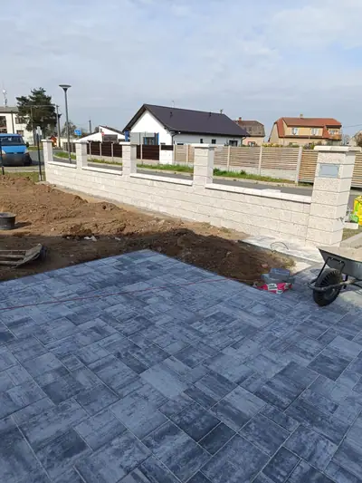 Nová plocha ze šedé dlažby a zděný plot ze štípaných tvárnic se sloupky