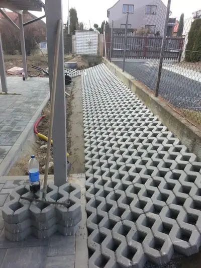 Vjezd ze zatravňovacích tvárnic mezi domem a plotem