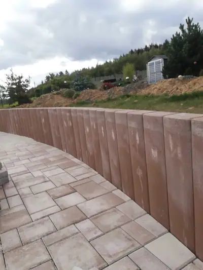 Vysoká opěrná stěna z palisád do oblouku a plocha z cihlové dlažby