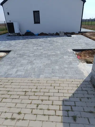 Velká plocha šedé dlažby před novým domem