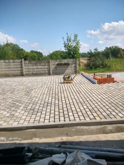 Velká plocha dlažby v teplém melíru a vibrační deska