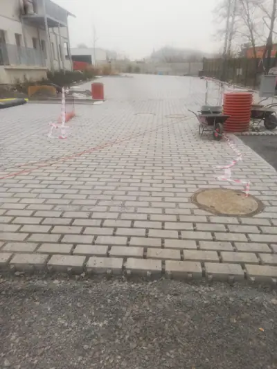 Dlážděné parkoviště ve světle šedé barvě při pokládce