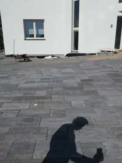 Velká plocha tmavé dlažby před domem
