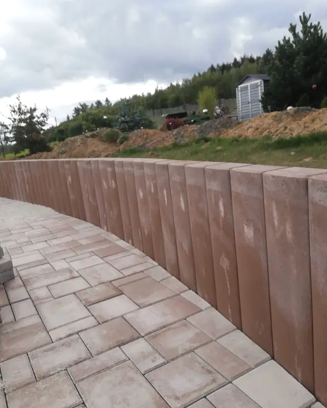 Vysoká opěrná stěna z palisád do oblouku a plocha z cihlové dlažby